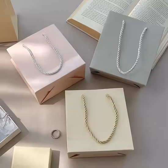 Bolsa de papel Kraft de compras de regalos de lujo barata al por mayor de fábrica OEM con logotipo personalizado